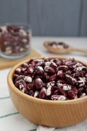 Photo of Bowl with dry kidney beans on table, closeup
