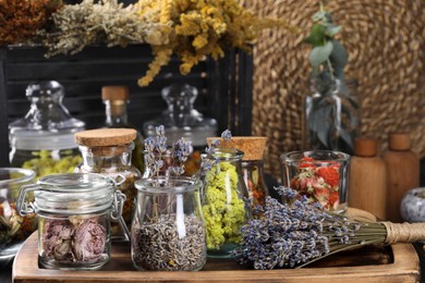 Many different herbs and dry lavender flowers on wooden table