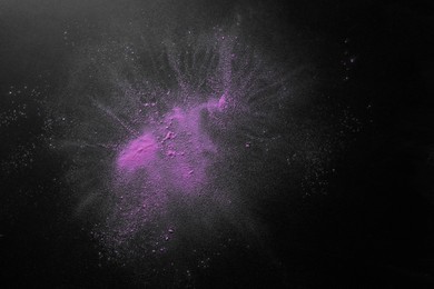 Photo of Violet powder dye on dark background, top view with space for text. Holi festival