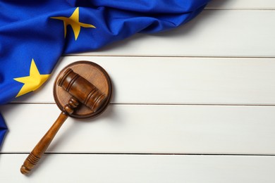 Photo of Judge's gavel and flag of European Union on white wooden table, flat lay. Space for text