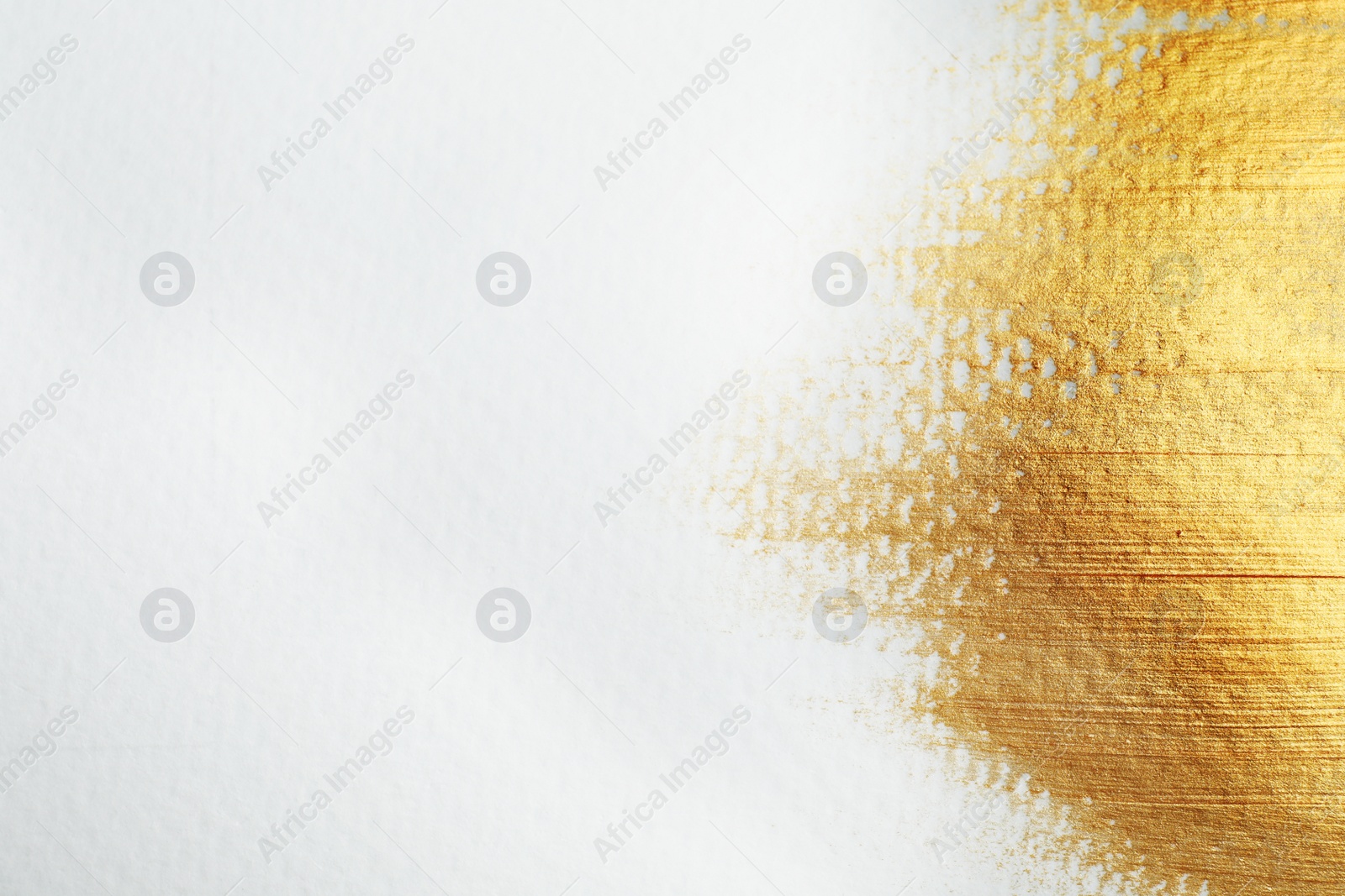 Photo of Golden paint on white background. Space for text