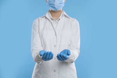 Photo of Dentist holding something on light blue background, closeup