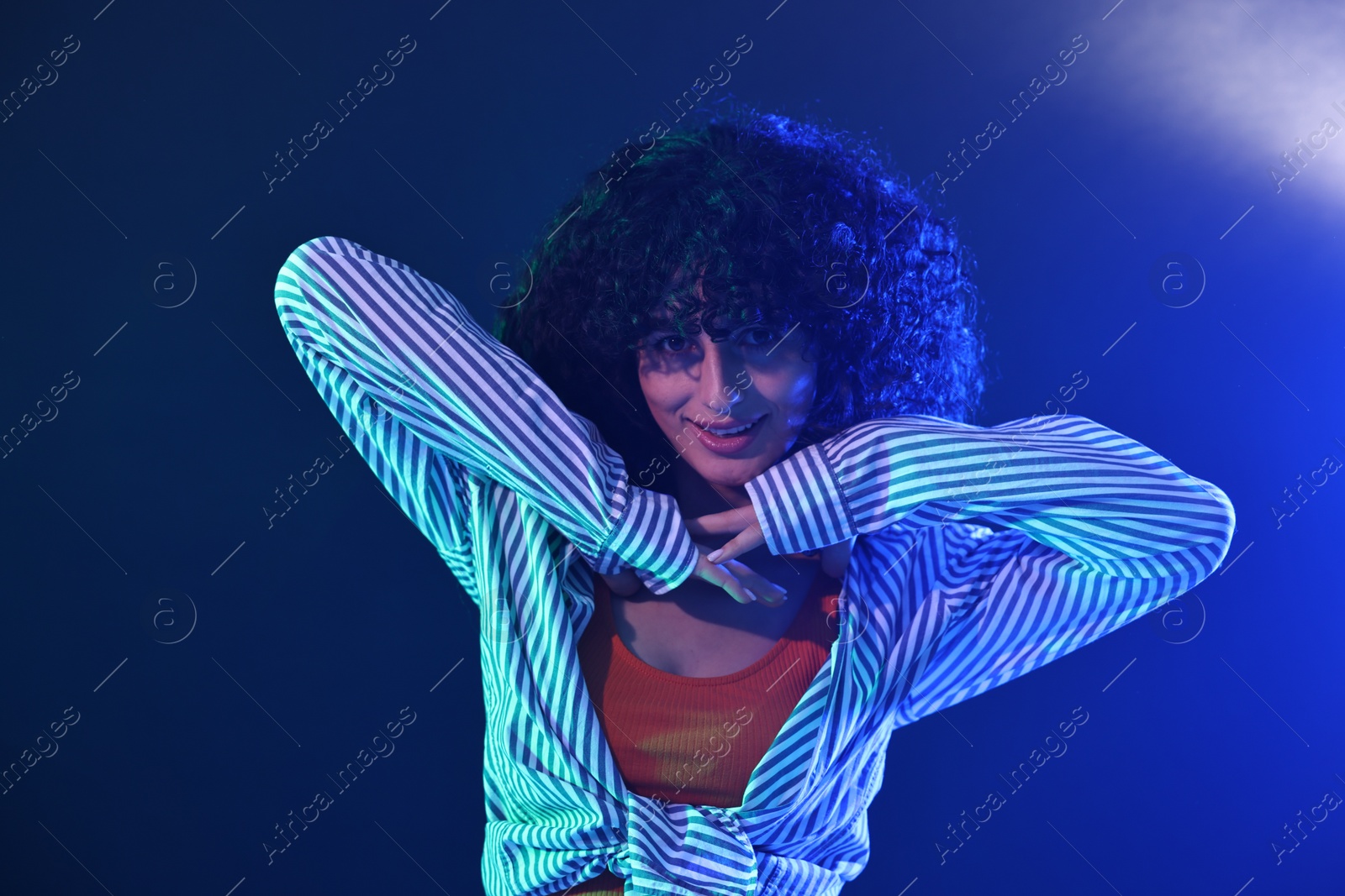 Photo of Beautiful young woman posing on color background in neon lights