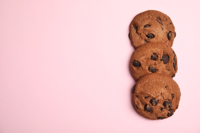 Photo of Delicious chocolate chip cookies on color background, flat lay. Space for text