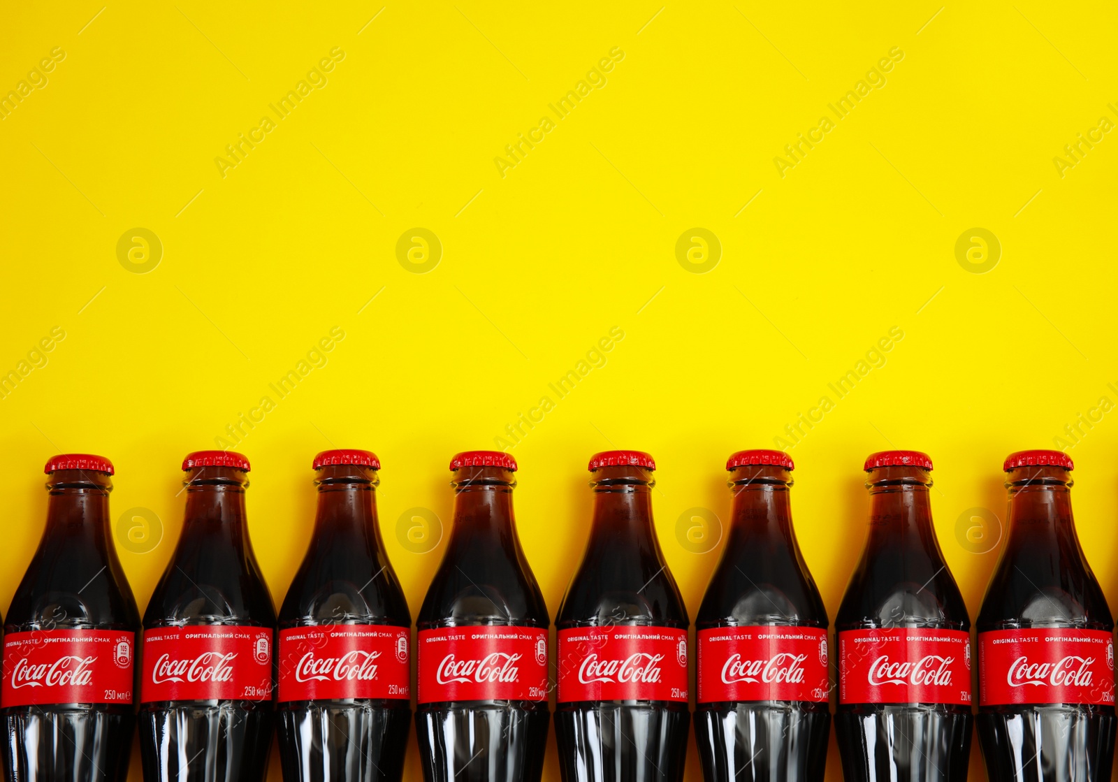 Photo of MYKOLAIV, UKRAINE - NOVEMBER 14, 2018: Bottles of Coca-Cola on color background, flat lay. Space for text