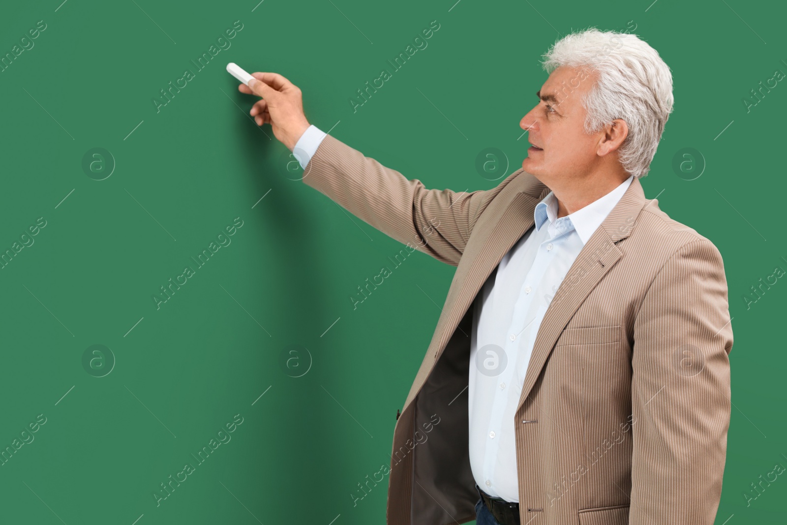 Photo of Portrait of senior teacher with chalk at green board, space for text