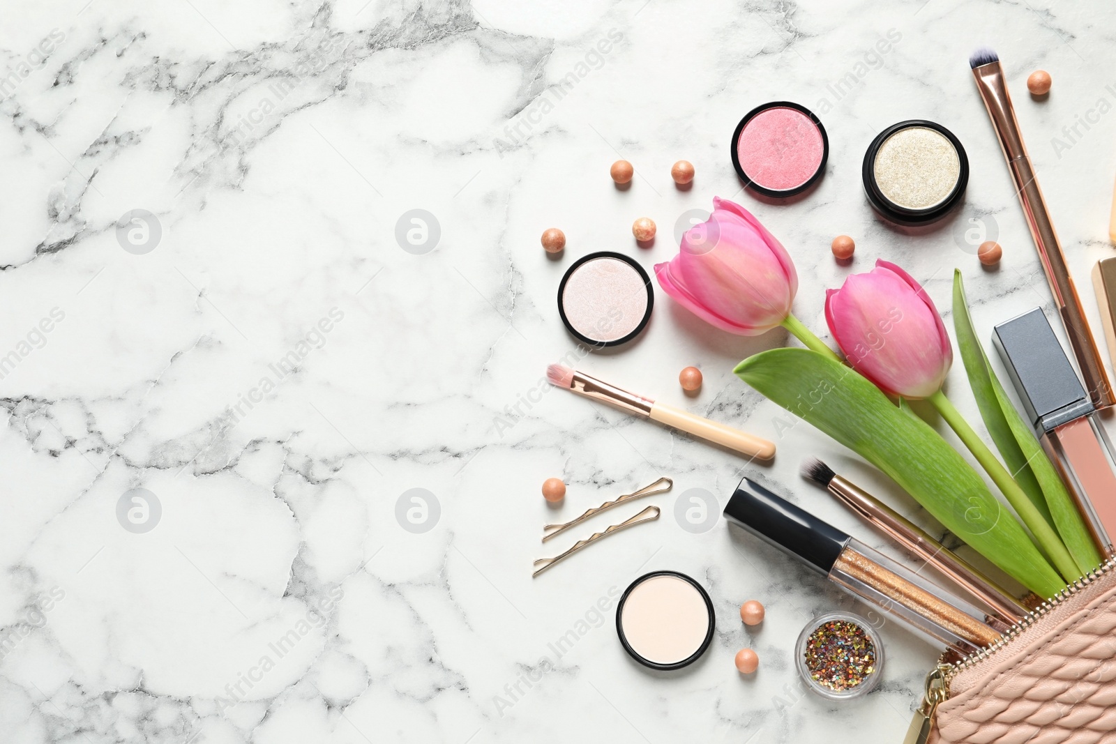 Photo of Many different makeup products and spring flowers on marble background, flat lay. Space for text