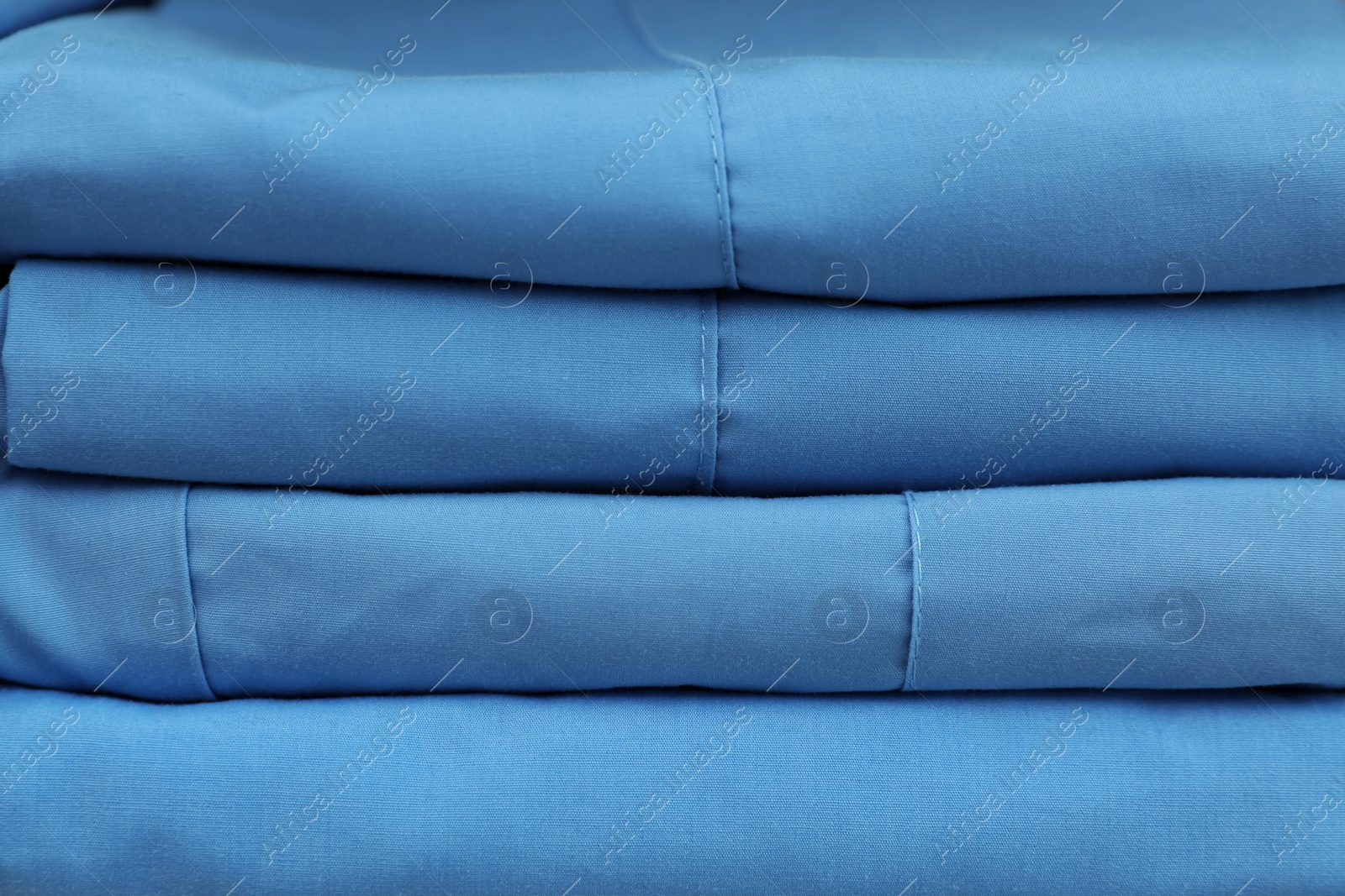 Photo of Light blue medical uniforms as background, closeup