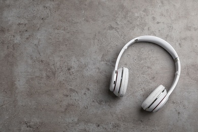 Stylish modern headphones and space for text on gray background, top view