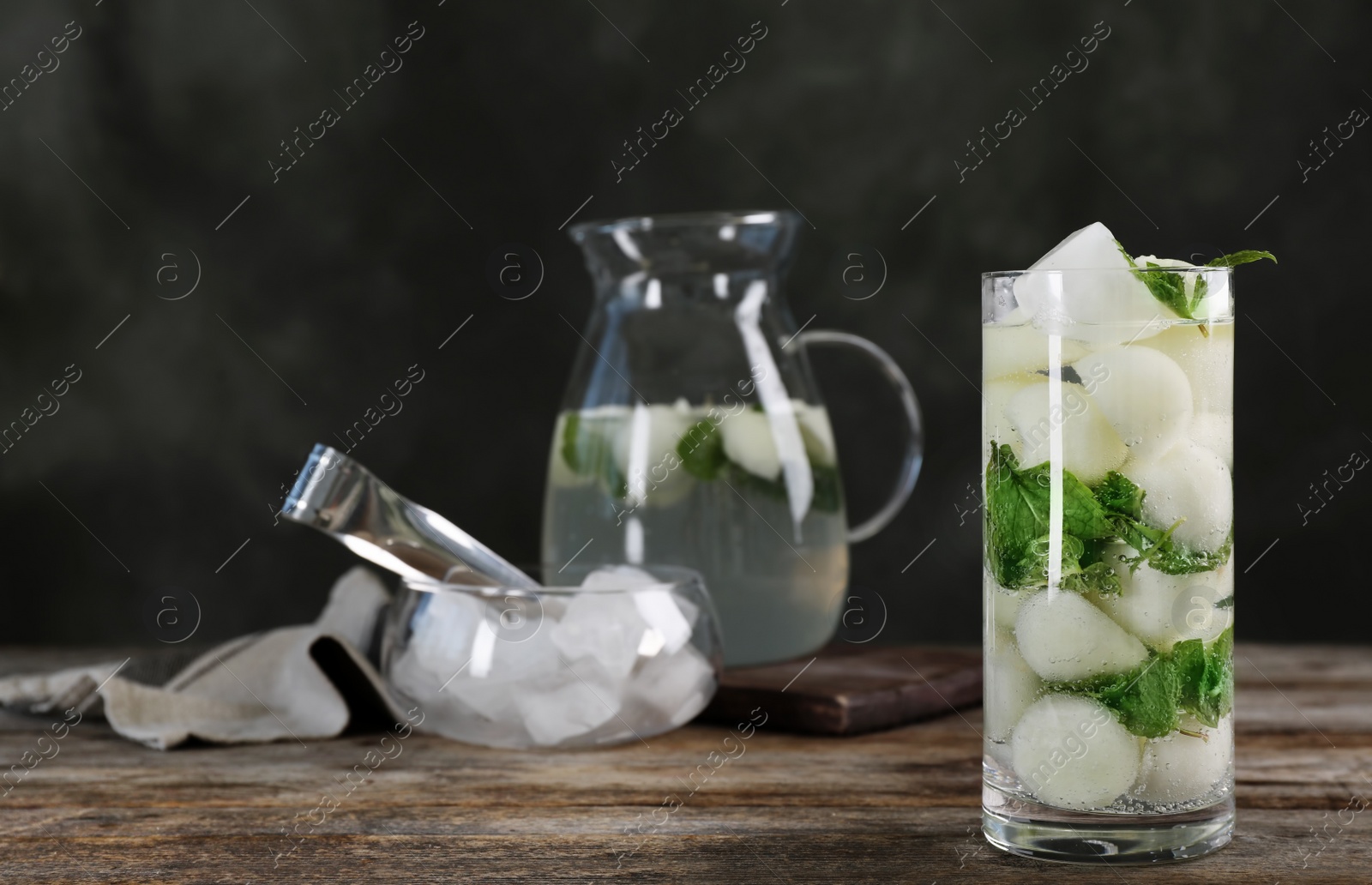 Photo of Glass with tasty melon ball drink on wooden table