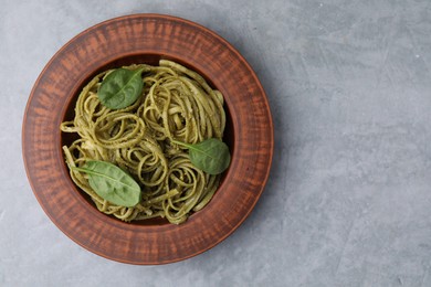 Photo of Tasty pasta with spinach on grey table, top view. Space for text