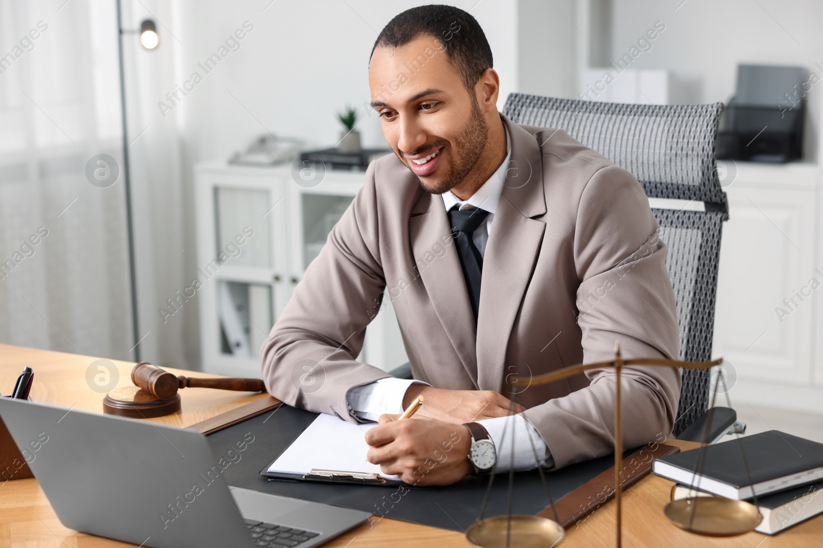 Photo of Smiling lawyer working at table in office