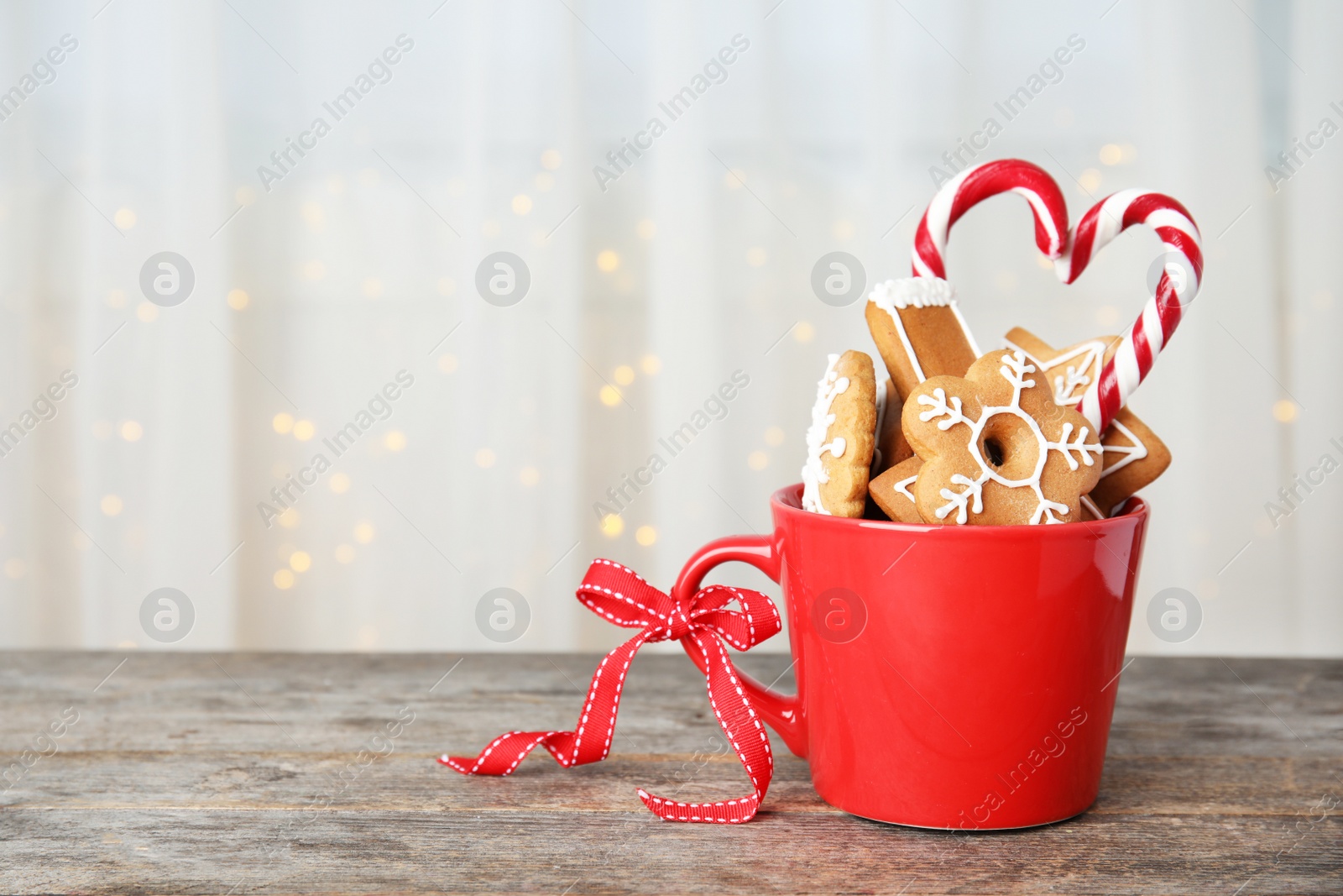 Photo of Cup with tasty homemade Christmas cookies on table