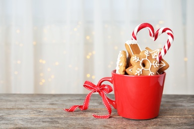 Photo of Cup with tasty homemade Christmas cookies on table