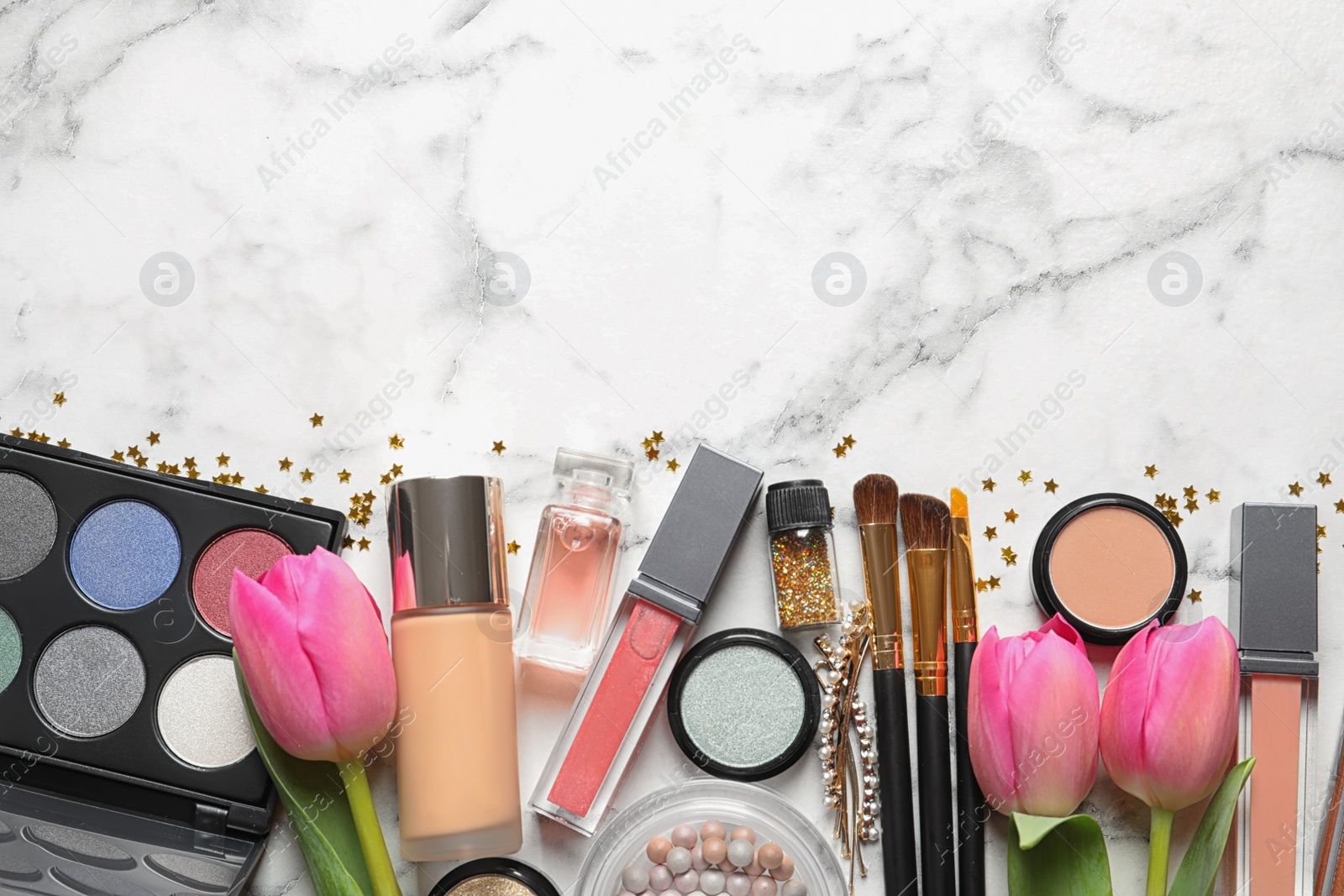 Photo of Makeup products and flowers on marble background, flat lay with space for text