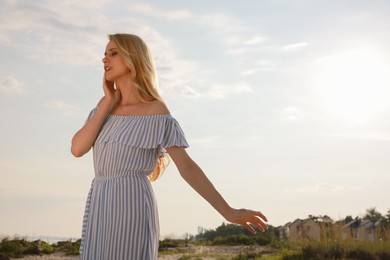 Beautiful young woman outdoors on sunny day, space for text