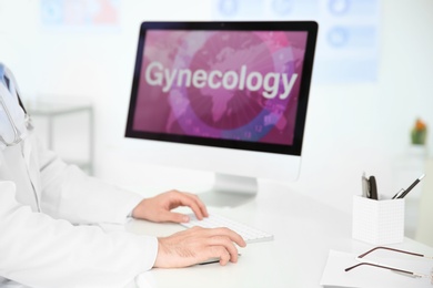 Photo of Young doctor working with computer in hospital. Gynecology department