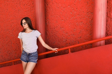 Photo of Young woman wearing gray t-shirt on staircase. Urban style