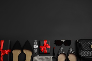 Photo of Gift boxes, shoes and stylish women's accessories on black background, flat lay. Space for text