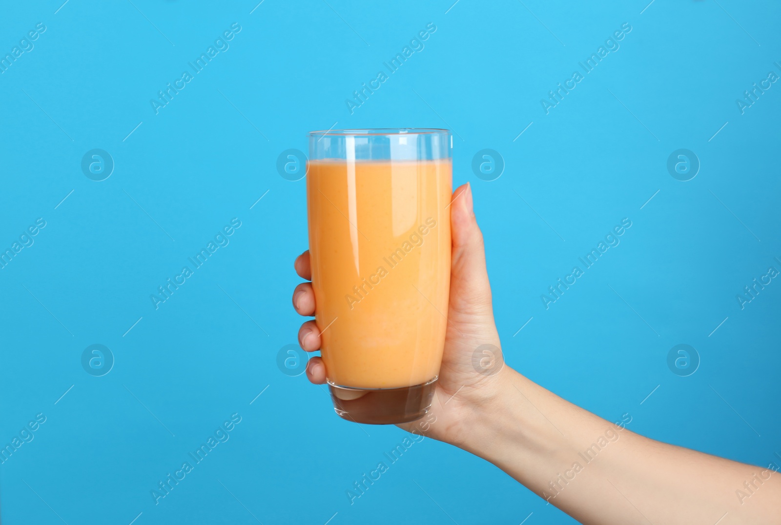 Photo of Woman holding glass with delicious smoothie on color background