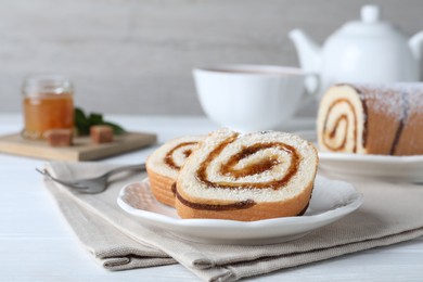 Photo of Tasty cake roll with jam on white wooden table