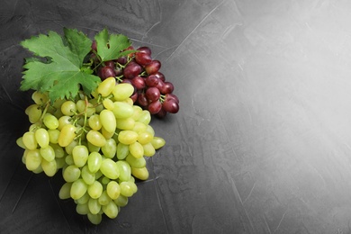 Photo of Fresh ripe juicy grapes on grey table, top view. Space for text