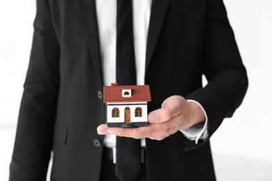 Photo of Male real estate agent with house model, closeup