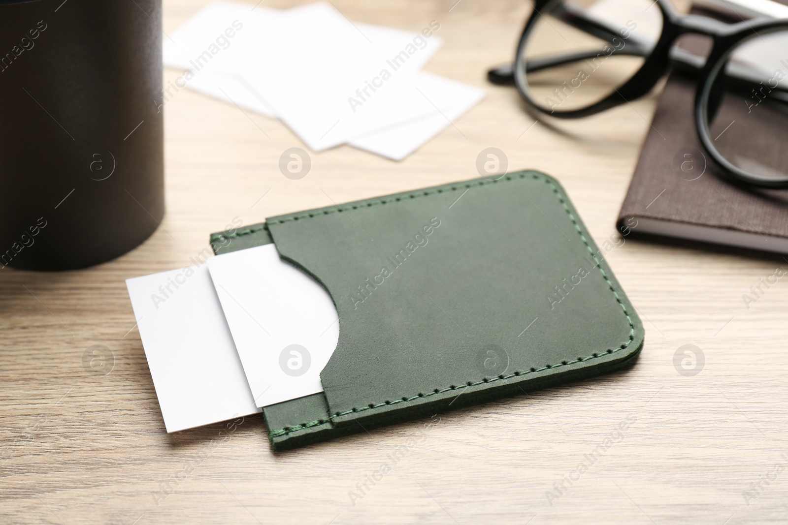 Photo of Leather business card holder with cards on wooden table
