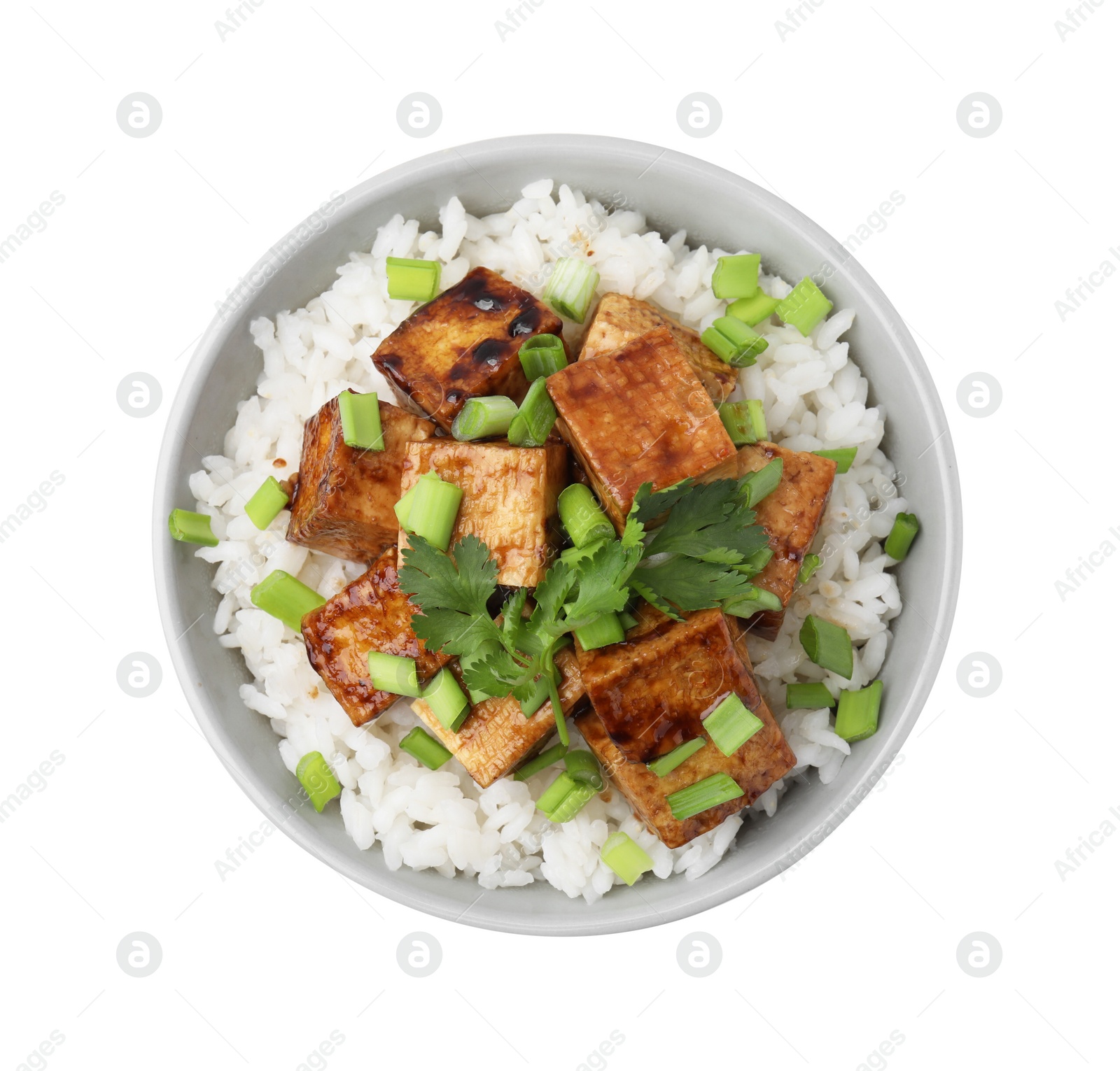 Photo of Bowl of rice with fried tofu and greens isolated on white, top view