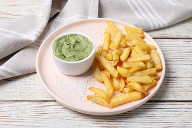 Photo of Plate with french fries and avocado dip on white wooden table