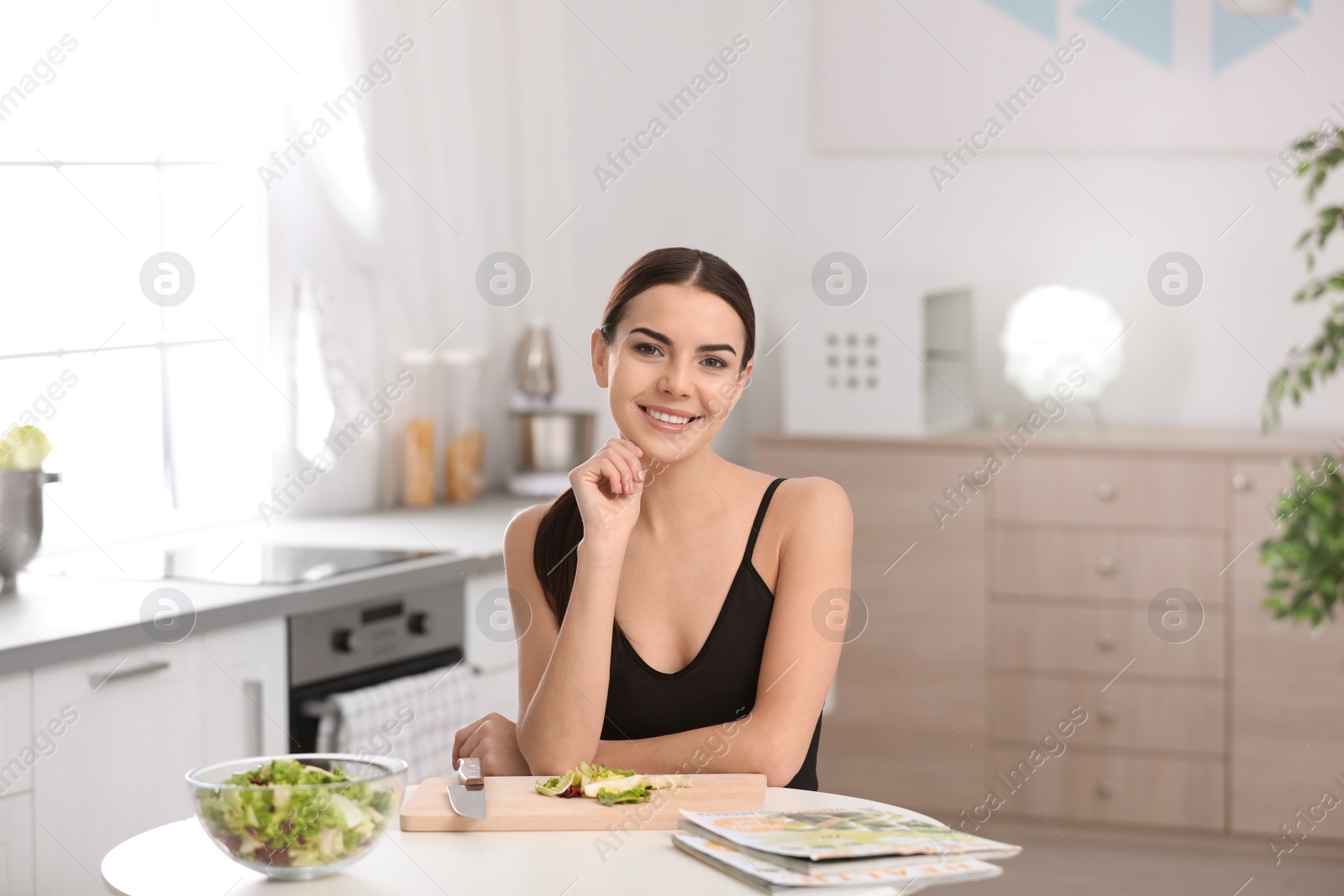 Photo of Young woman in fitness clothes preparing healthy breakfast at home