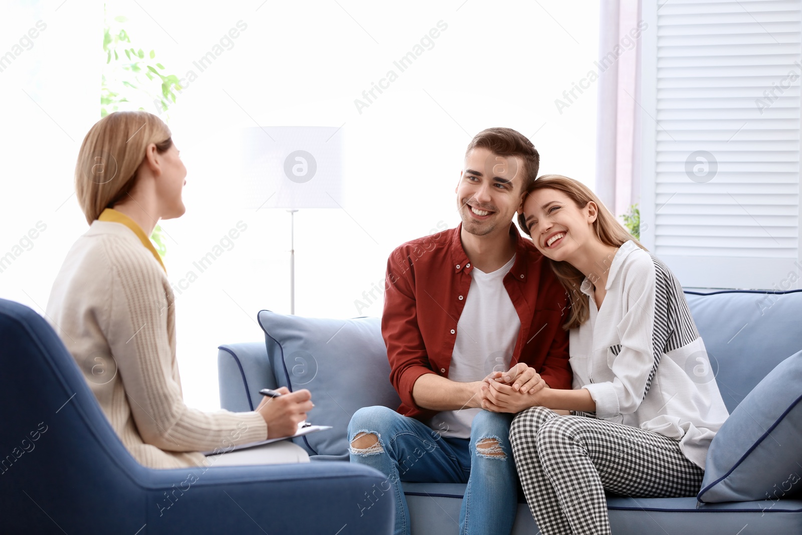 Photo of Young happy couple after therapy session with family psychologist indoors