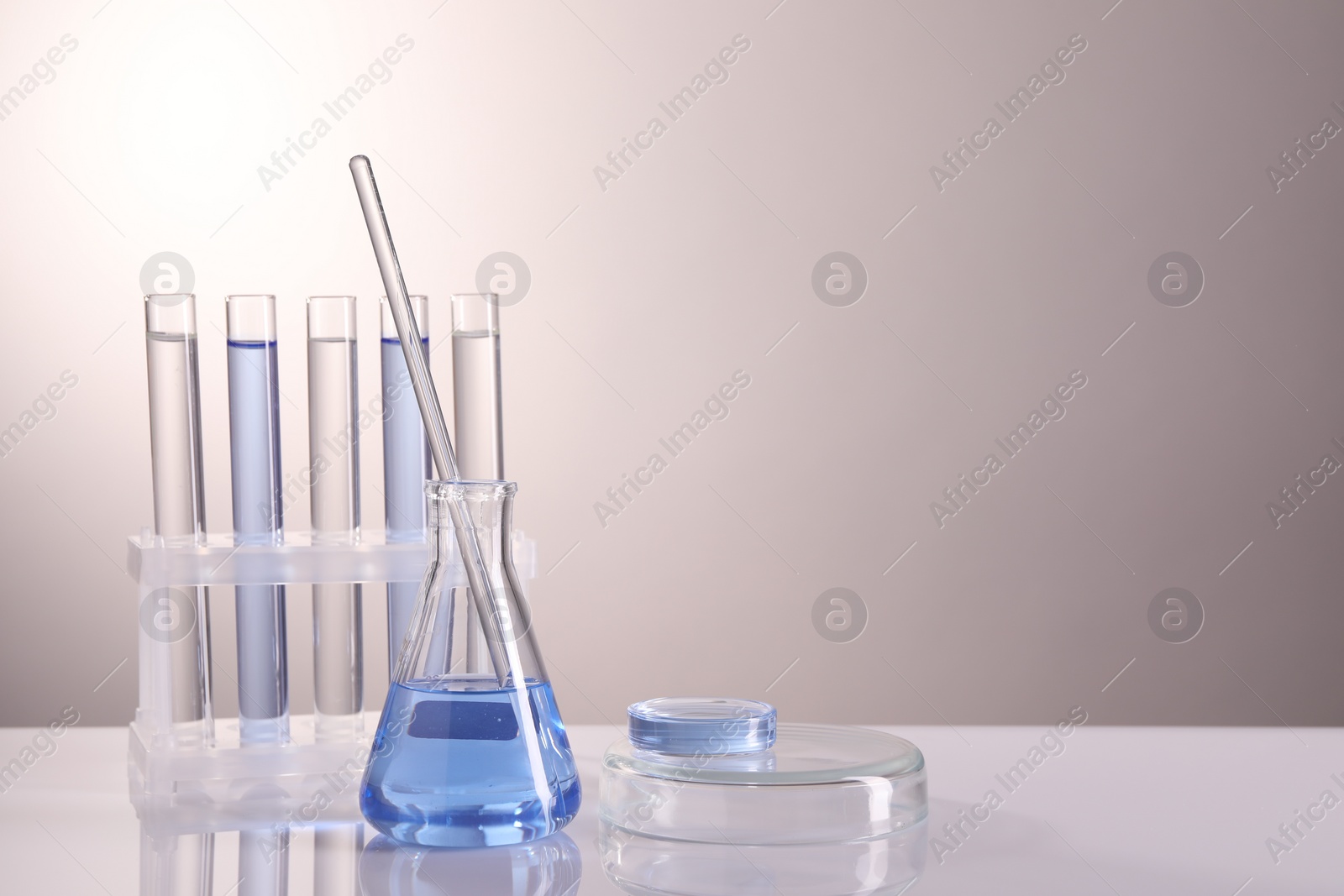 Photo of Laboratory analysis. Different glassware on table against light background, space for text