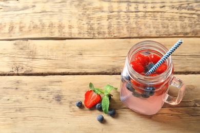 Natural lemonade with berries in mason jar on wooden table