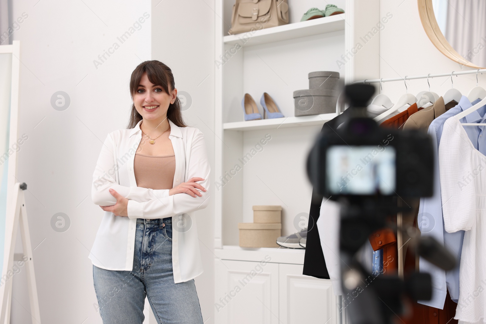 Photo of Smiling fashion blogger recording video at home