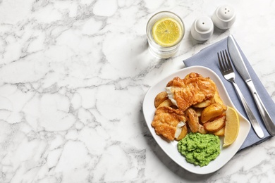 Plate with British traditional fish and potato chips on marble background, top view. Space for text