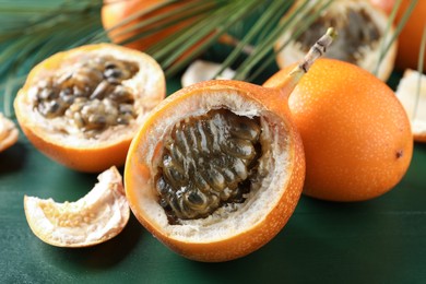 Delicious ripe granadillas on green wooden table, closeup