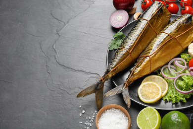 Photo of Tasty smoked fish served on dark table, space for text