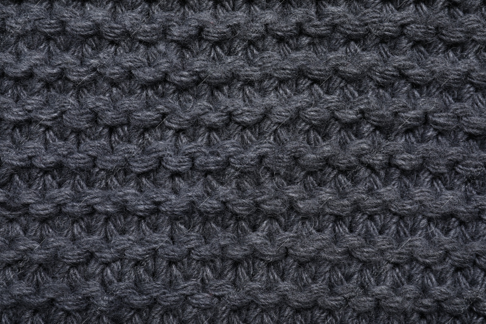 Photo of Gray knitted scarf as background, top view