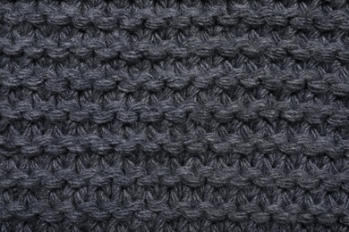 Photo of Gray knitted scarf as background, top view