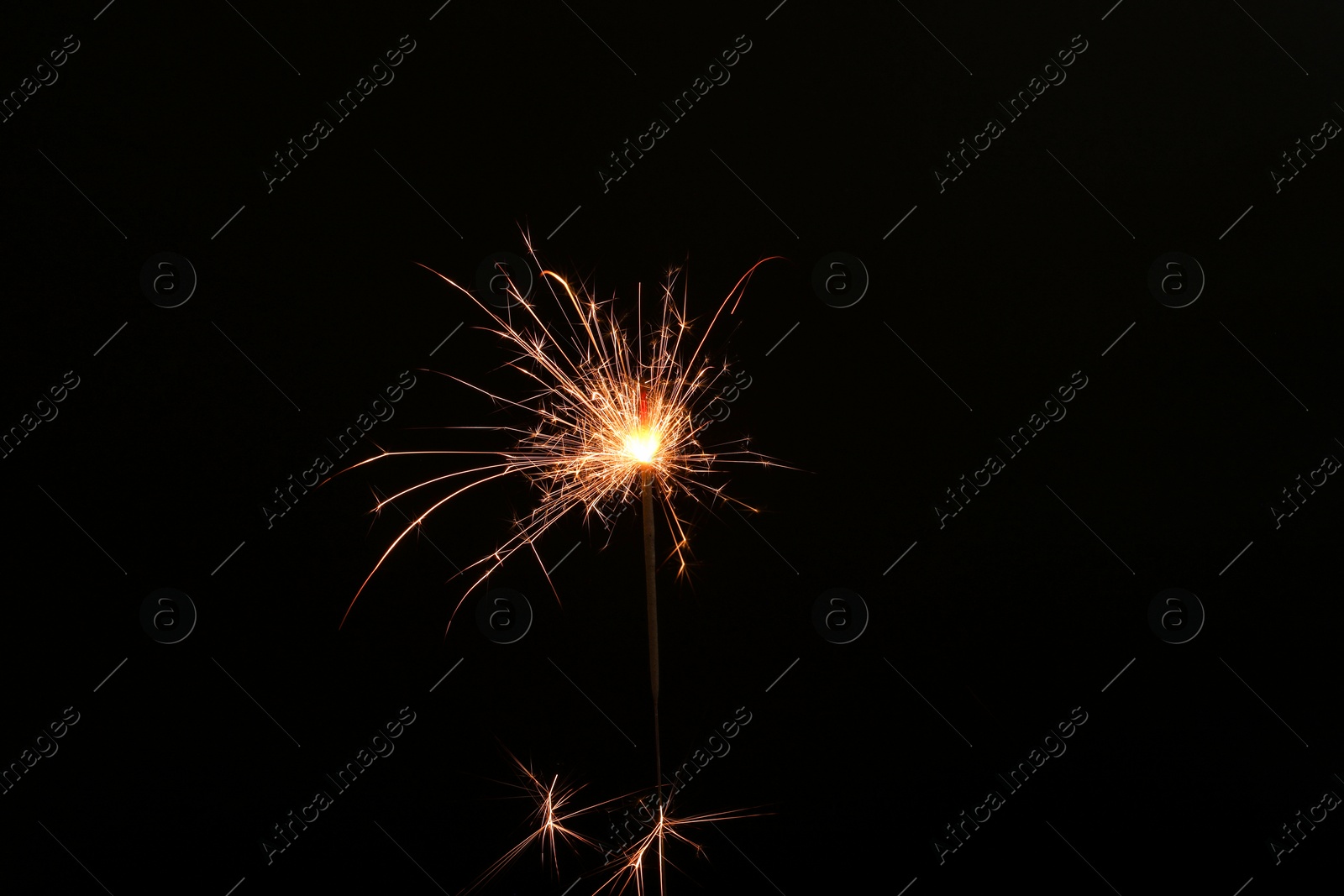 Photo of Burning sparkler stick on black background, space for text