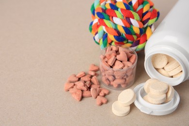 Photo of Different pet vitamins and toy on beige background, space for text