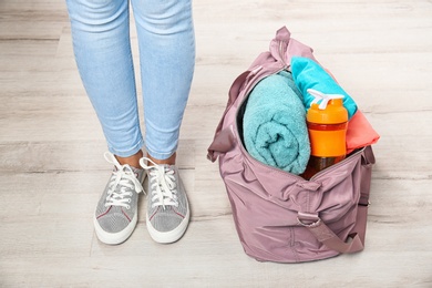 Photo of Young woman and sports bag with gym equipment, closeup. Ready for sport training