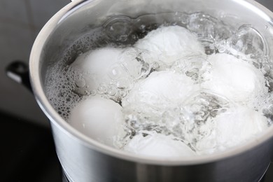 Chicken eggs boiling in saucepan, closeup view