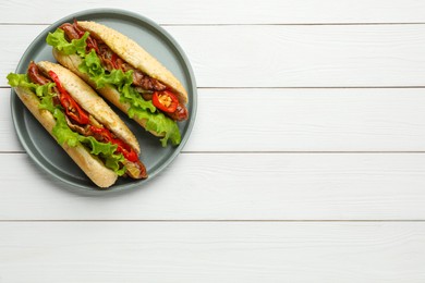 Tasty hot dogs on white wooden table, top view with space for text. Fast food