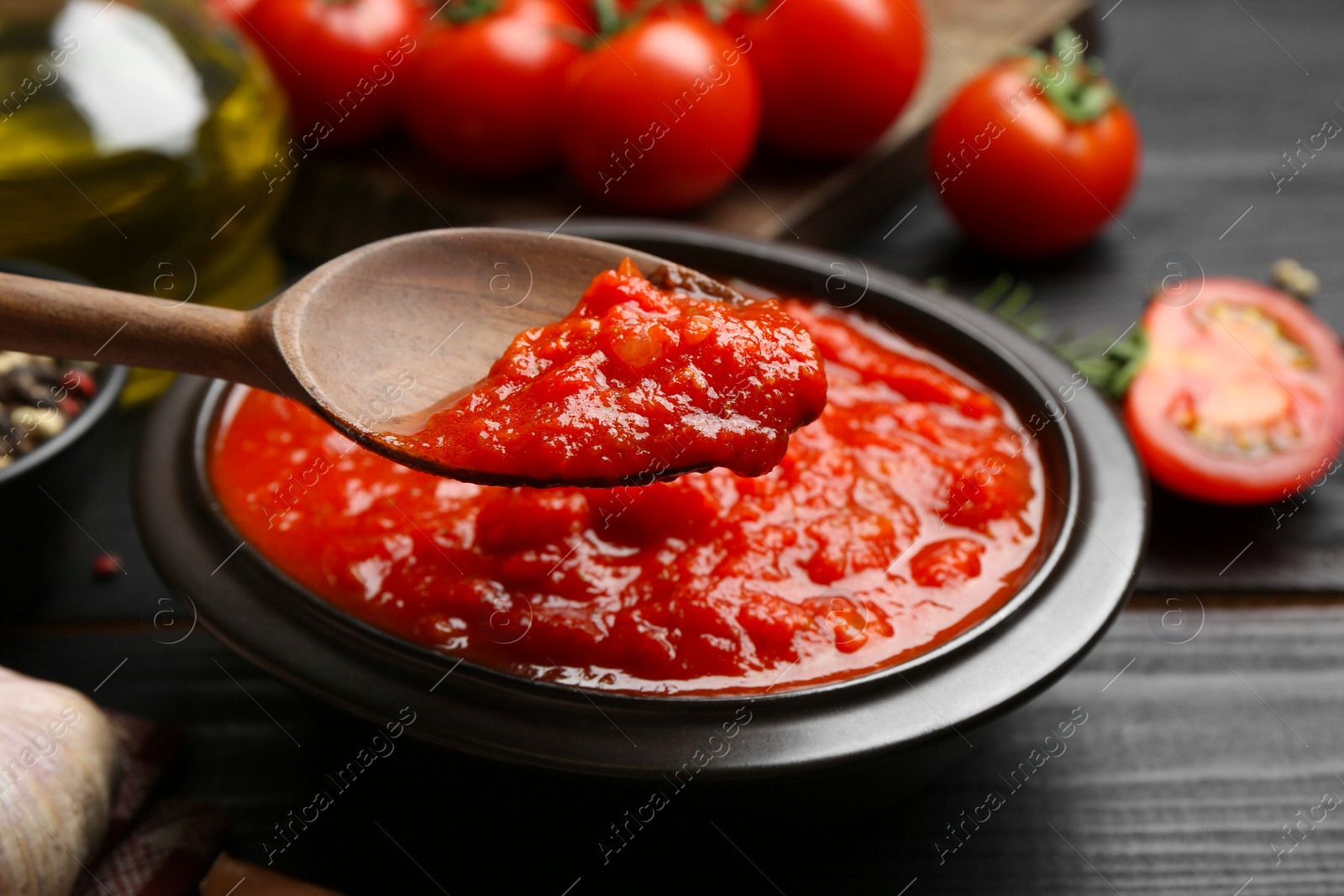 Photo of Eating homemade tomato sauce at black table, closeup