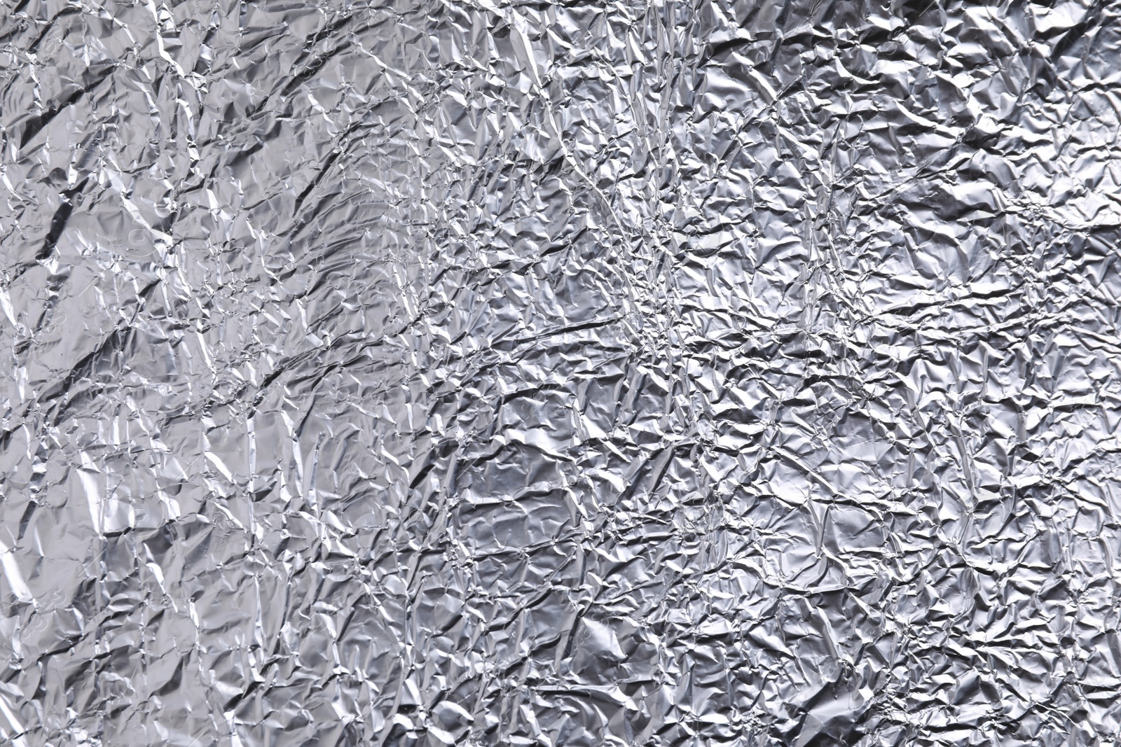 Photo of Crumpled silver foil as background, closeup view