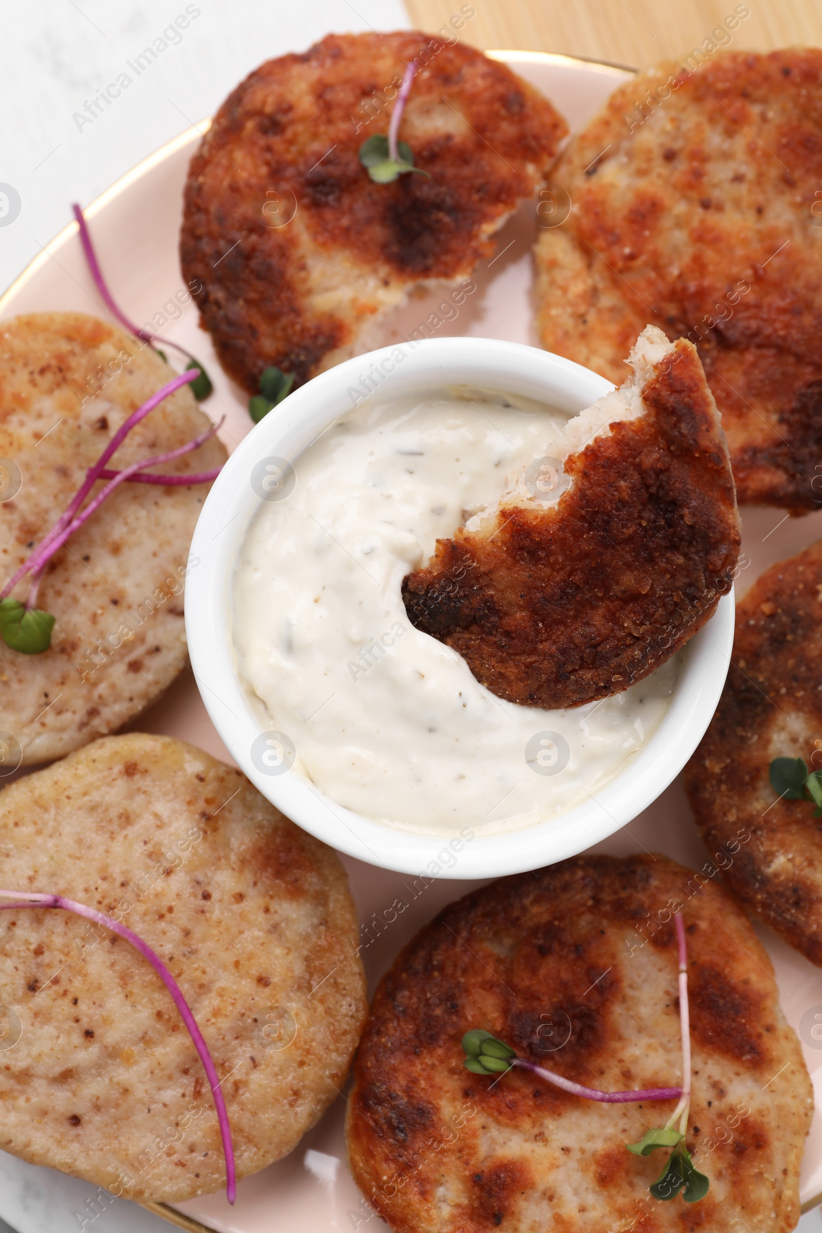 Photo of Delicious vegan cutlets and sauce on pink plate, top view