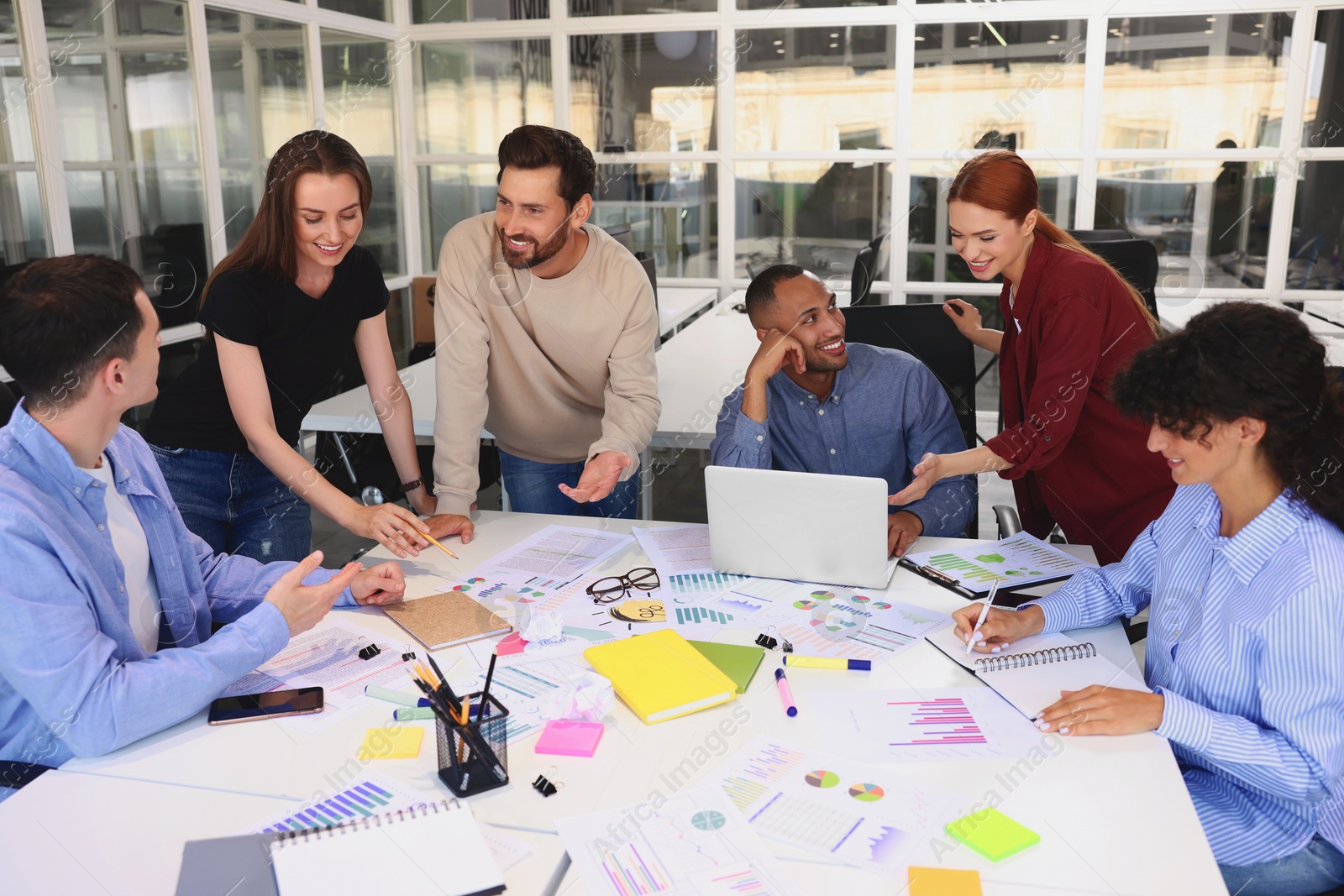 Photo of Team of employees working together at table in office. Startup project