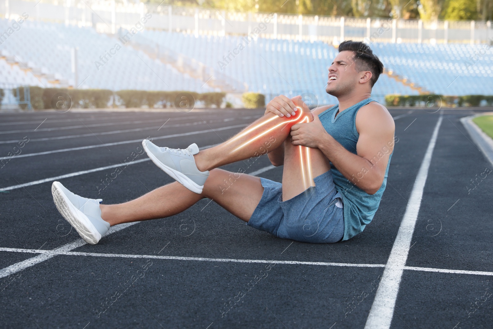 Image of Digital composite of highlighted bones and man suffering from leg pain at stadium